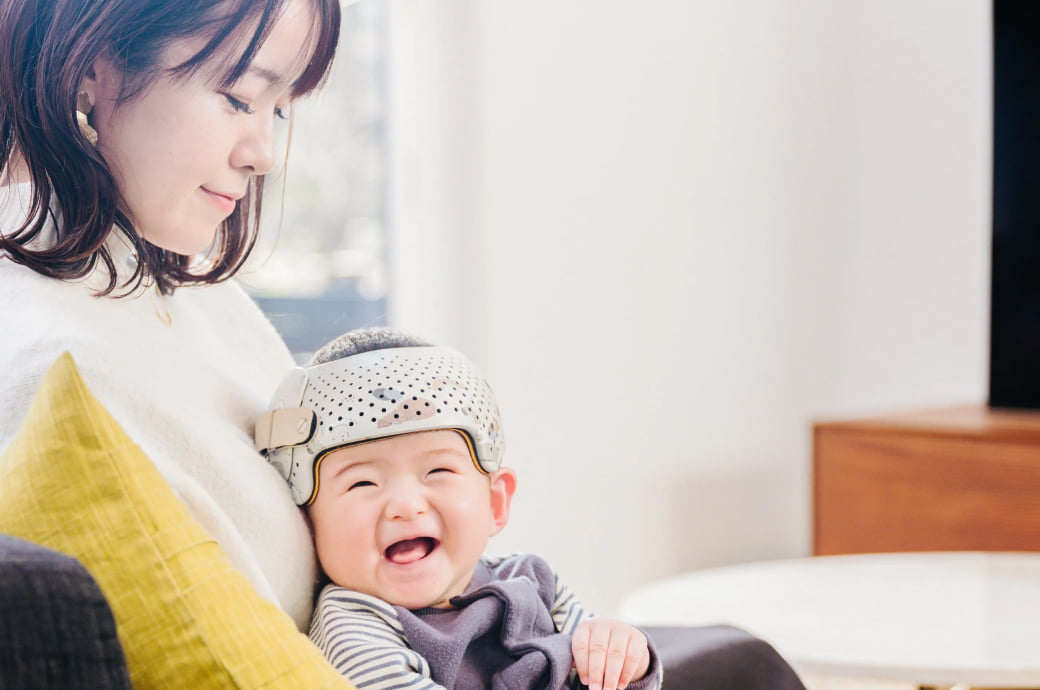 ベビーバンドをつけた笑顔の赤ちゃんの写真