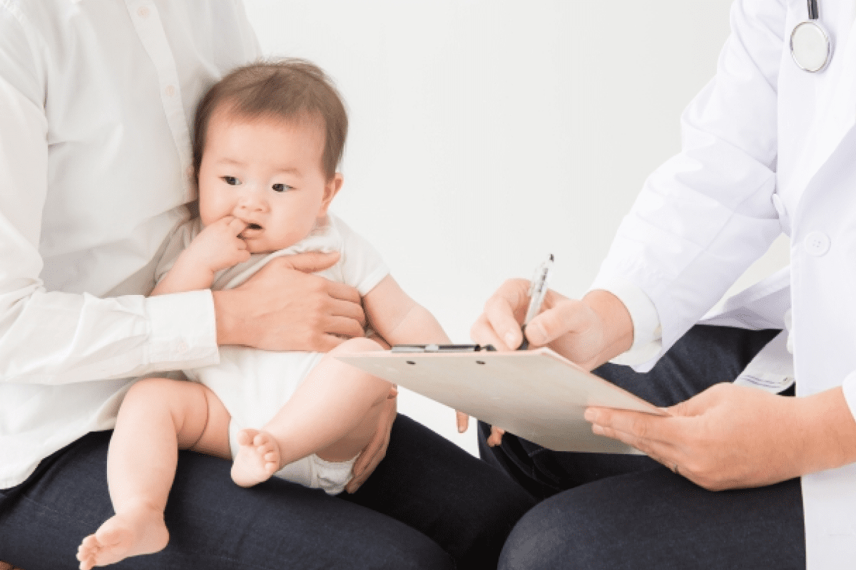 赤ちゃんを抱っこする親と、説明する医師